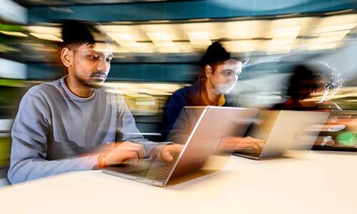 Computer science students Dhruv Kamalesh Kumar, Aravind Dasarathy and Rudra Sett work on a project in the ISEC building. Photo by Matthew Modoono/Northeastern University