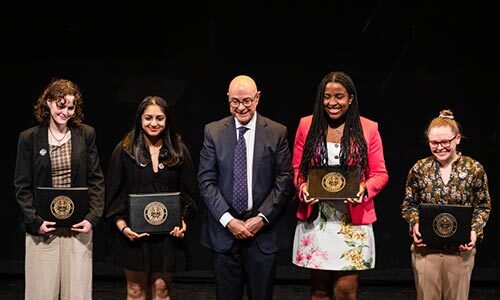 Northeastern President Joseph E. Aoun applauds Matthew Miller, recipient of the University Distinguished Professor Award.