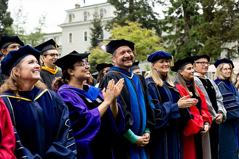 Khoury faculty smile and applaud during the ceremony