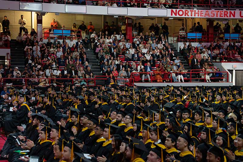 Dozens of rows of graduates were seated on the arena floor during the ceremony as the crowd looks on from their seats