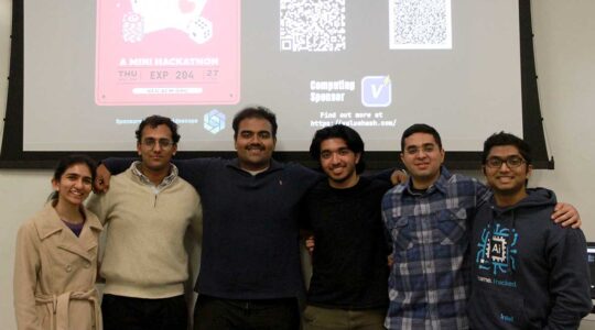 Six members of the ACM club stand in front of a presentation screen about a mini hackathon event