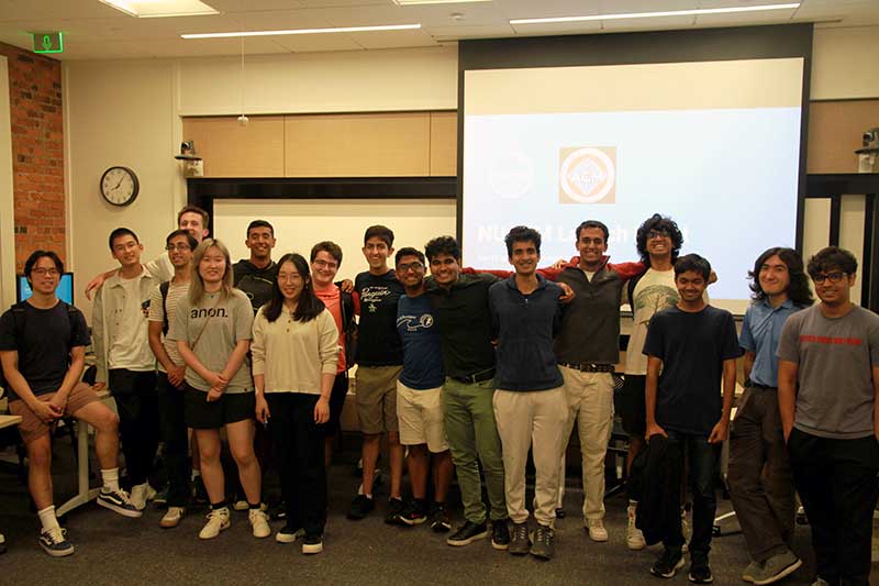 17 members of the NU ACM club pose for a photo in a conference room