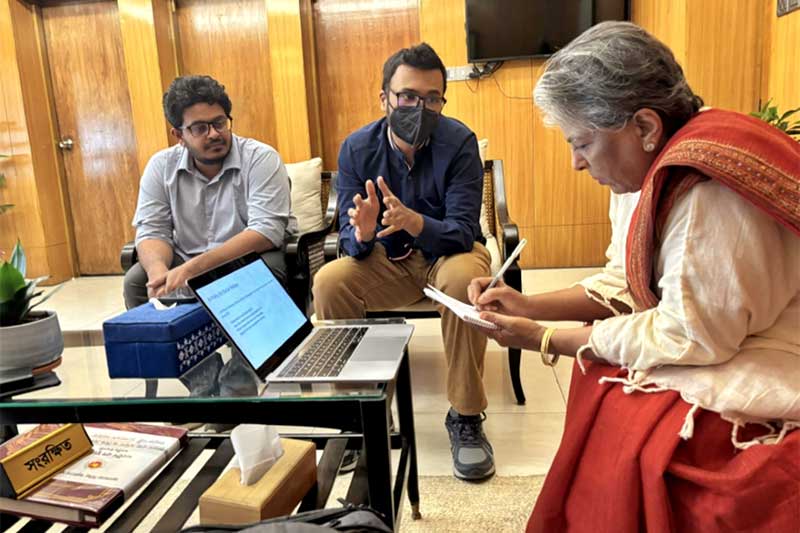 Upol Ehsan (center) explains responsible AI fundamentals to the Hon. Sharmeen Murshid (right), the leader of Bangladesh’s Ministry of Social Welfare.