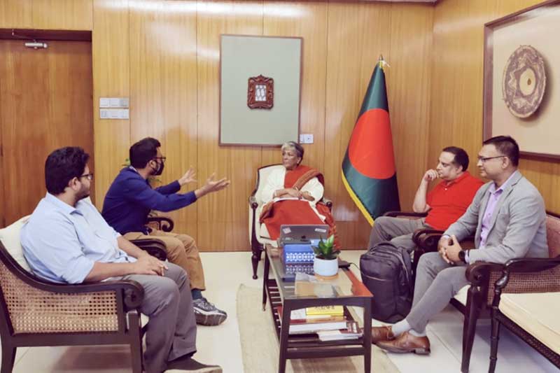 Upol Ehsan (second from left) discusses responsible AI fundamentals to the Hon. Sharmeen Murshid (center), the leader of Bangladesh’s Ministry of Social Welfare, and three other people.