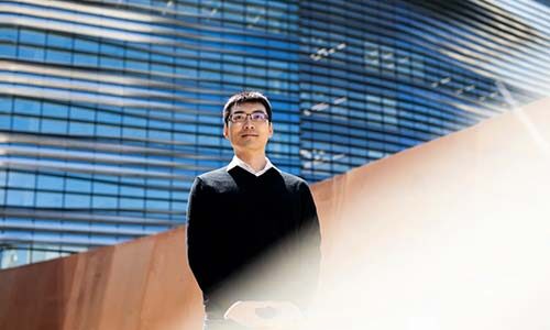 Dakuo Wang stands in front of the EXP building