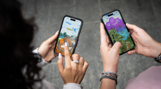 Two people are holding smartphones to depict a Pokemon-inspired tool that helps entrepreneurs fairly split ownership of a new company.