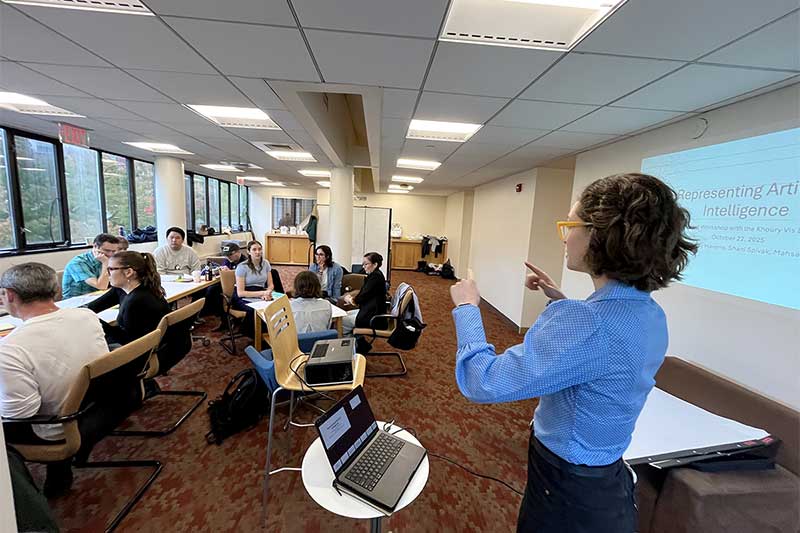 Lucy Havens gestures while speaking to a room of researchers