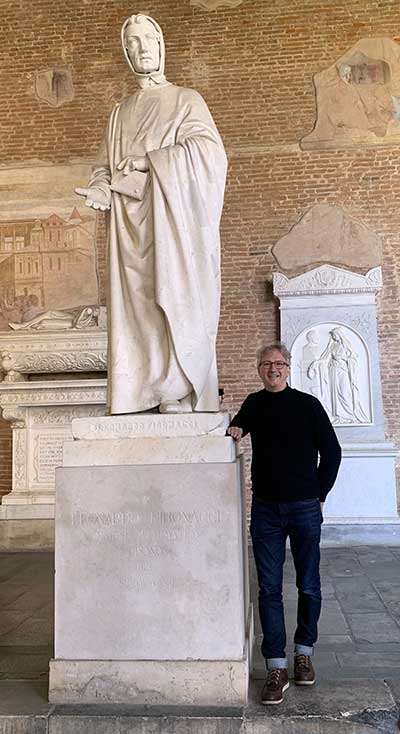 Walter Hürsch stands next to a statue of Leonardo Bonacci