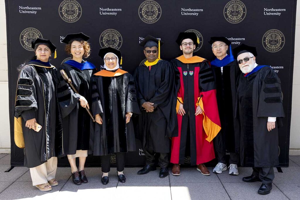 Faculty from Northeastern Silicon Valley pose for a photo while wearing graduation regalia