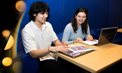 Dylan Kao and Lucy Paolini sit at a table during their co-op with NU Oakland’s Lead by Learning