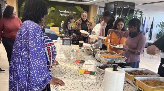 Members of NU Arlington's African Students Network get plates of food at a club event