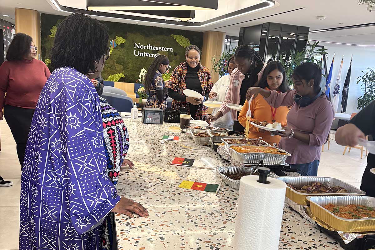 Members of NU Arlington's African Students Network get plates of food at a club event