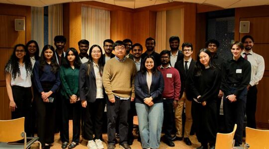 Twenty Khoury master's students pose for a photo before the research showcase