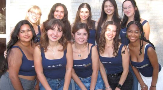 Ten members of Phi Sigma Rho stand in two rows while posing for a photo