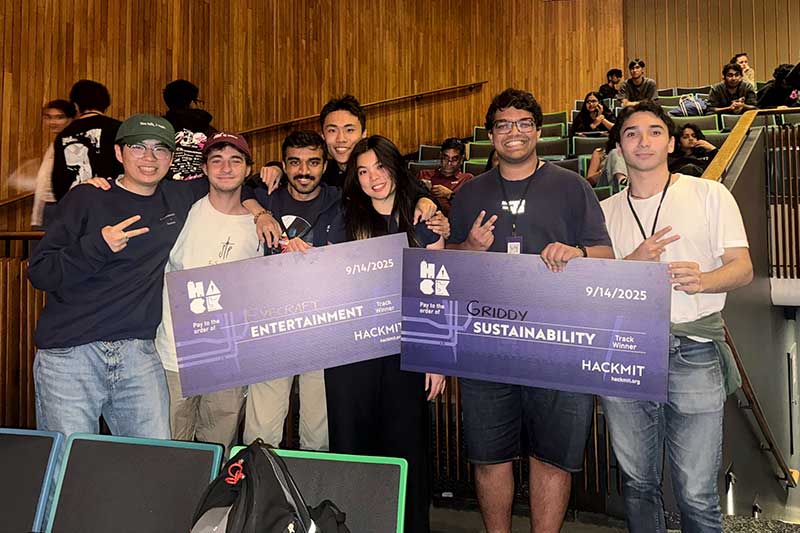 The Eyecraft and Griddy teams post with their novelty prize checks in an auditorium