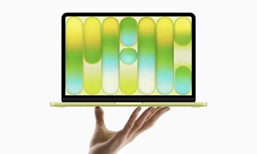 a hand holds an Apple Macbook Neo