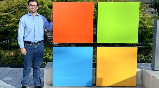 Benjamin Meyer stands next to a model of the Microsoft logo