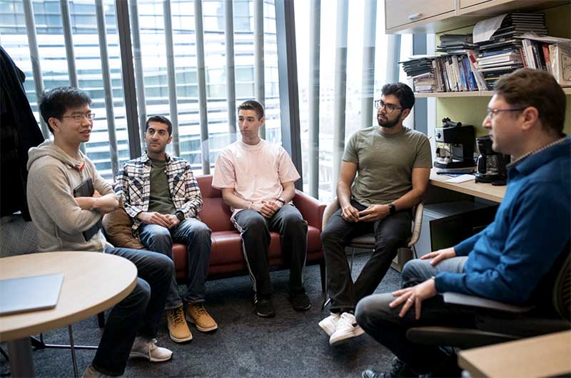 Engin Kirda (right) talks with members of his lab in his office
