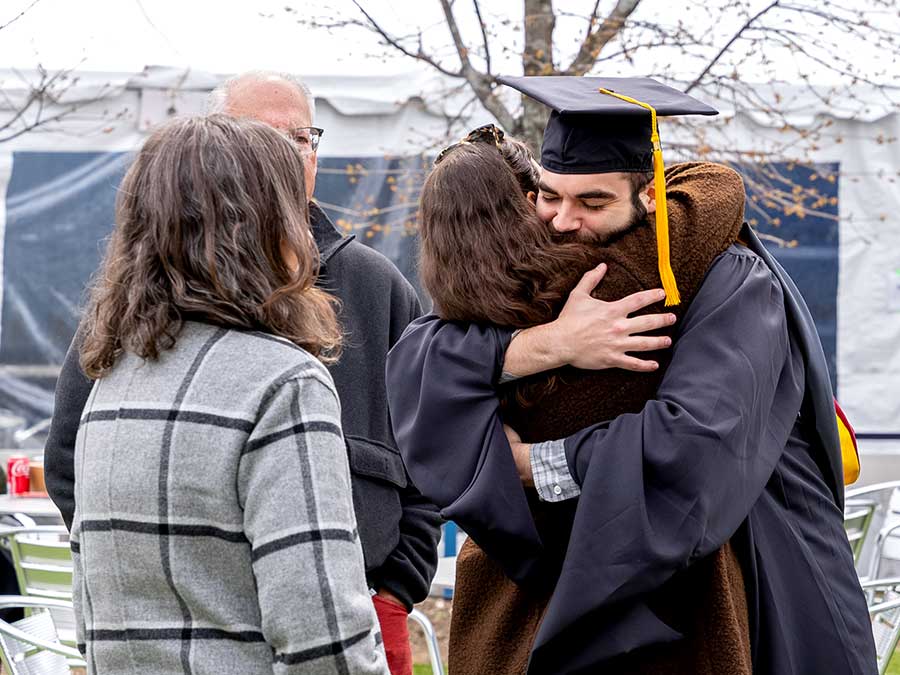 A Khoury graduate hugs a friend
