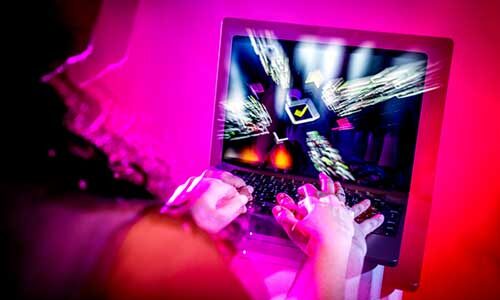 A graphic showing a blurry photo of a person typing on a laptop with a screen showing a giant checkbox
