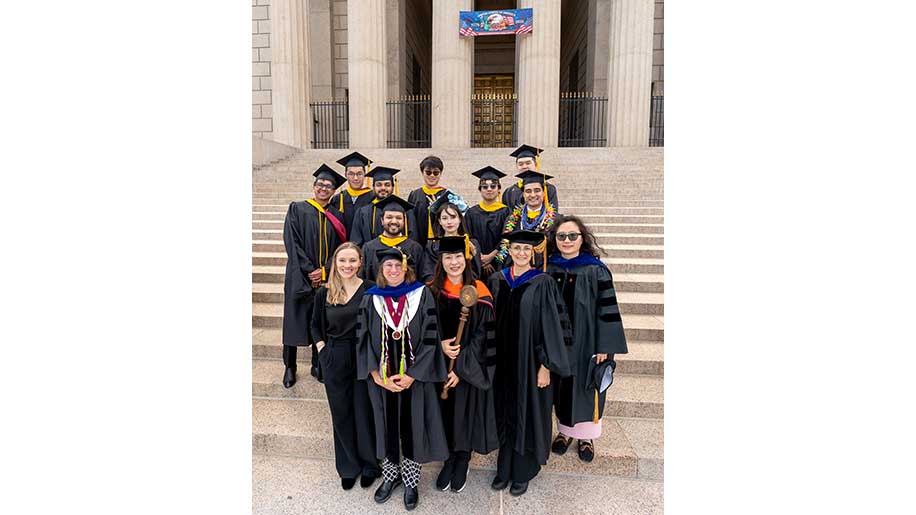 Students gather with Khoury staff and faculty at the May 8 Commencement, including (first row, left to right) Madison Barton, Beth Hawthorne, Youna Jung, Katherine Socha, and Huihui Wang