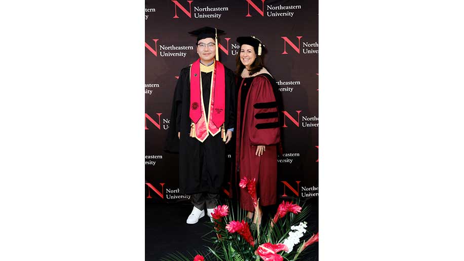 A Khoury graduate stands with a member of Northeastern University Miami's administration