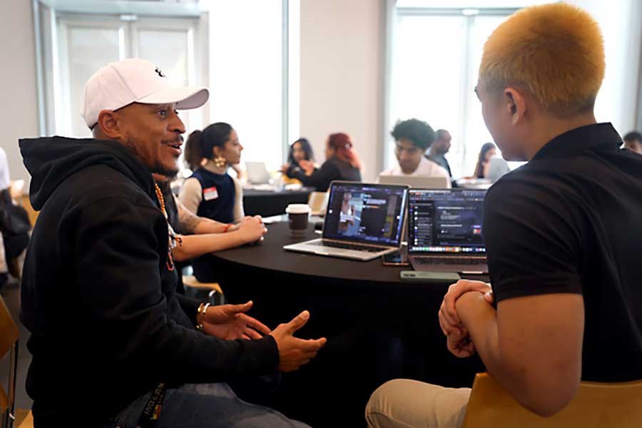 A Khoury student speaks with a local business leader at a large table