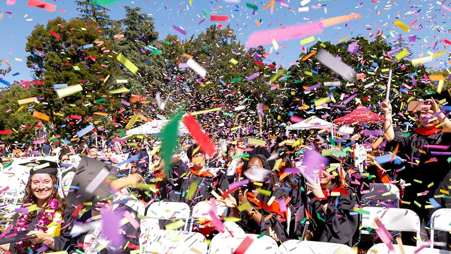 Confetti falls upon many rows of graduates