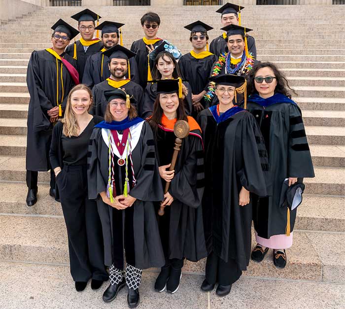 Students gather with Khoury staff and faculty at the May 8 Commencement, including (first row, left to right) Madison Barton, Beth Hawthorne, Youna Jung, Katherine Socha, and Huihui Wang