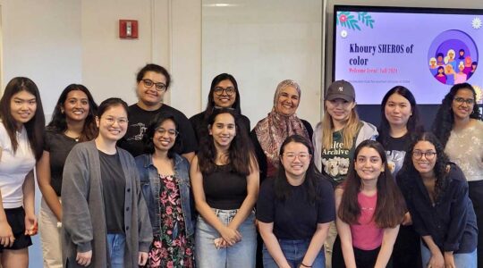 13 members of Khoury SHEROS pose with advisor Ghita Amor-Tijani
