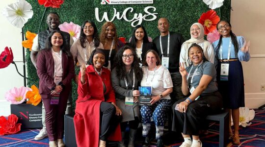 Members of NU Arlington's Women's in Cybersecurity club pose for a photo with faculty