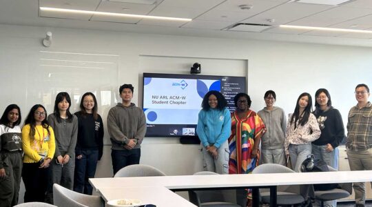 11 members of the NU Arlington ACM-W chapter pose for a photo in a classroom