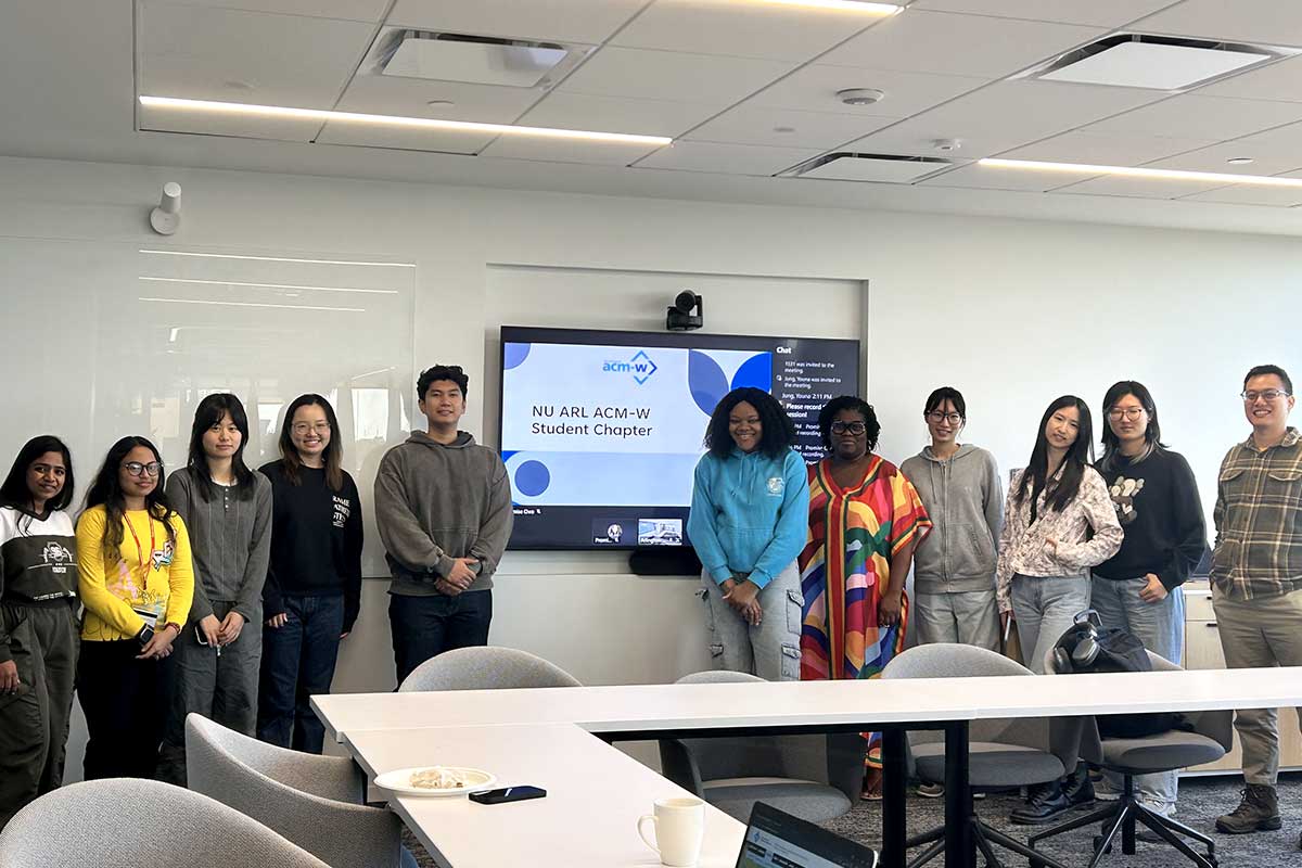 11 members of the NU Arlington ACM-W chapter pose for a photo in a classroom