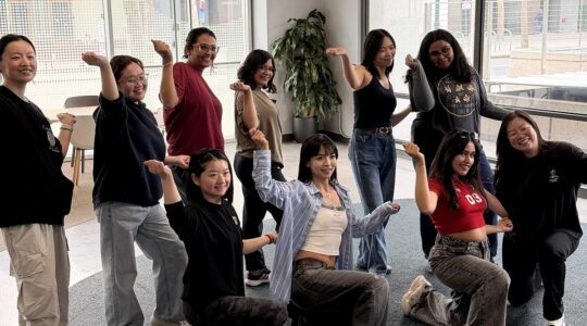 Ten members of HusK Pop practice a dance routine in a studio