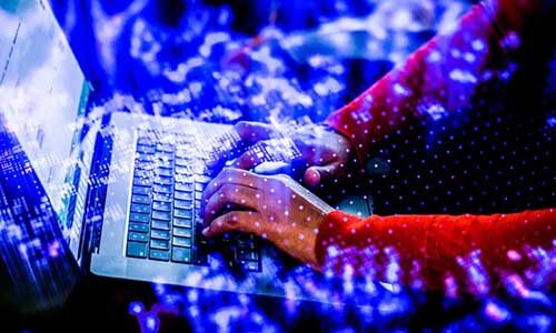 A person types at a laptop computer