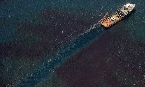 an overhead view of an oil tanker moving through an ocean