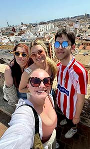 A Northeastern student takes a selfie with three other students on top of a roof in Spain